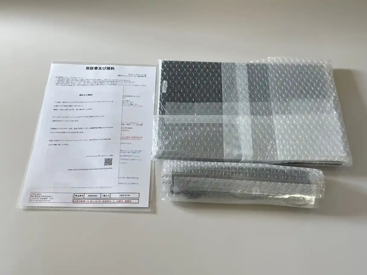 ジャンクワールドから届いた保証書及び規約とプチプチで包まれたノートパソコン